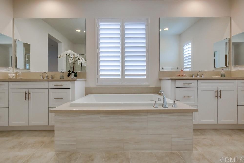 13413 Red Oak Way San Diego, CA 92130 - Photo 16 of 25 a spacious bathroom with a granite countertop tub sink and mirror
