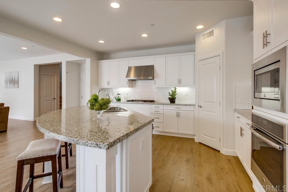 13413 Red Oak Way San Diego, CA 92130 - Photo 8 of 25 a kitchen with granite countertop sink cabinets and stainless steel appliances