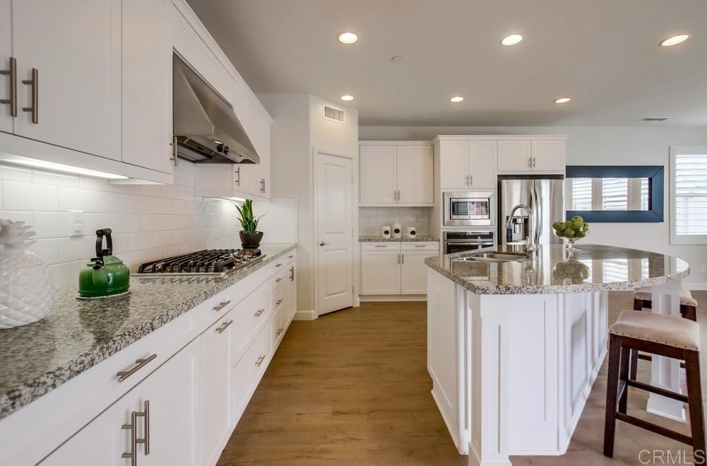 13413 Red Oak Way San Diego, CA 92130 - Photo 10 of 25 a large kitchen with stainless steel appliances lots of counter space and wooden floor