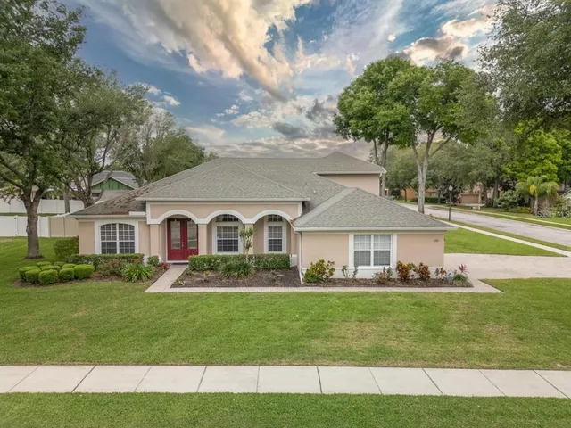 a front view of a house with a garden and trees