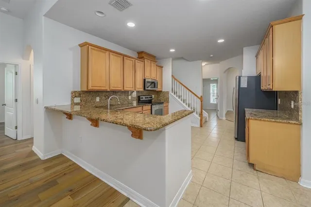 a kitchen with kitchen island granite countertop a sink a counter top space and cabinets