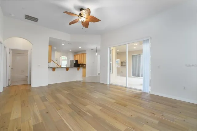a view of a big room with wooden floor and a kitchen