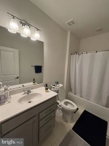 a bathroom with a double vanity sink toilet and a mirror