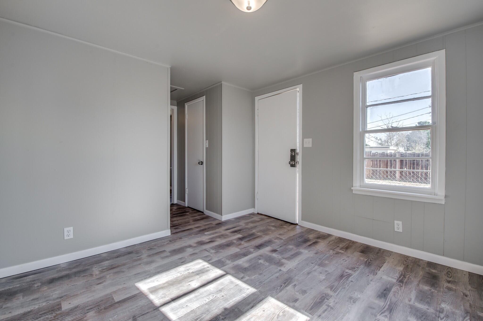 4813 40th Street, Unit REAR Lubbock, TX 79414 - Photo 2 of 7 an empty room with wooden floor and windows