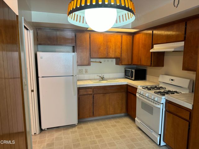 a kitchen with a refrigerator sink stove and cabinets