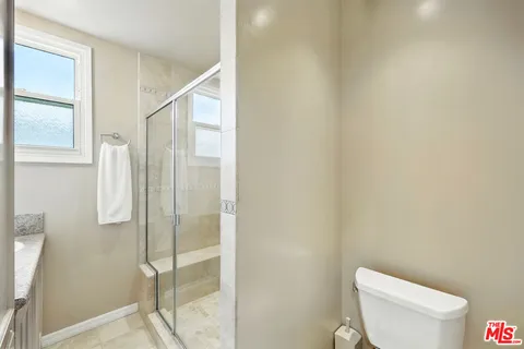 a white toilet sitting next to a shower