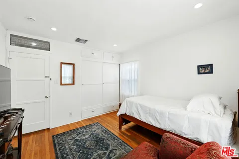 a bedroom with a bed and a lamp with the wooden floor