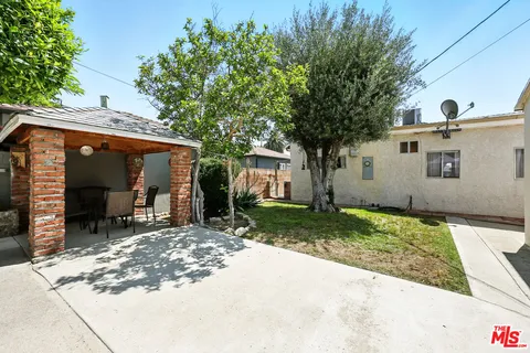 a view of a chair and table in backyard of the house