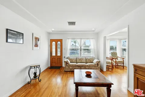a living room with furniture and a wooden floor