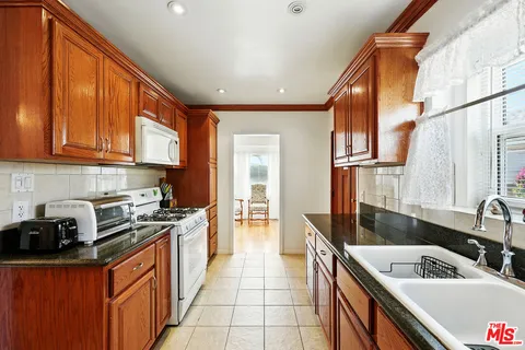 a kitchen with stainless steel appliances granite countertop a sink stove and cabinets