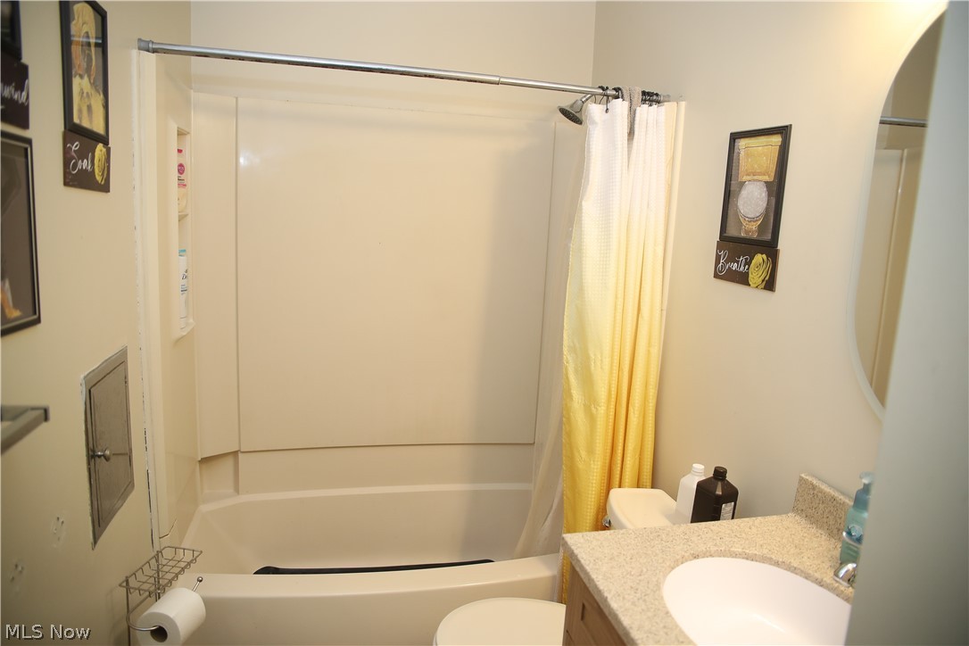 1258 Vane Avenue Akron, OH 44310 - Photo 9 of 12 Bathroom featuring a white tub/shower combination, a vanity with a light-colored countertop, and an oval mirror