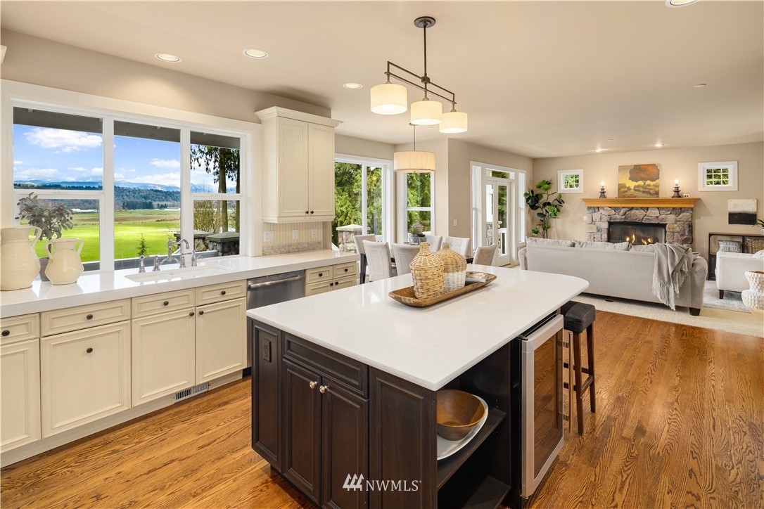 8707 West Snoqualmie Valley Road Northeast Carnation, WA 98014 - Photo 14 of 39 a kitchen with a stove a sink a kitchen island with wooden cabinets and wooden floor