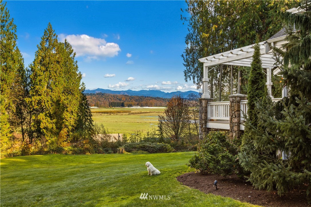 8707 West Snoqualmie Valley Road Northeast Carnation, WA 98014 - Photo 6 of 39 a view of a garden with a building in the background