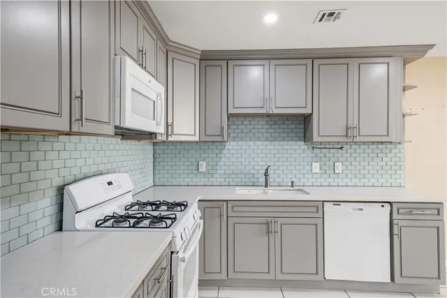 a kitchen with stainless steel appliances a sink stove and cabinets