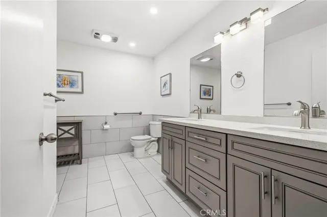 a spacious bathroom with a granite countertop sink a toilet and a mirror