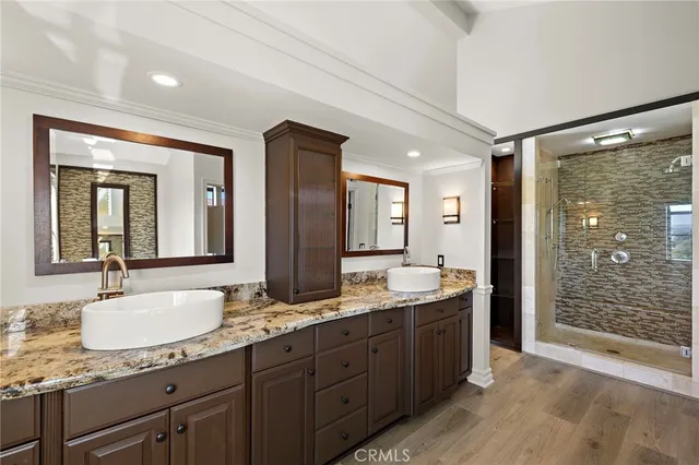 a bathroom with double vanity sinks and a shower
