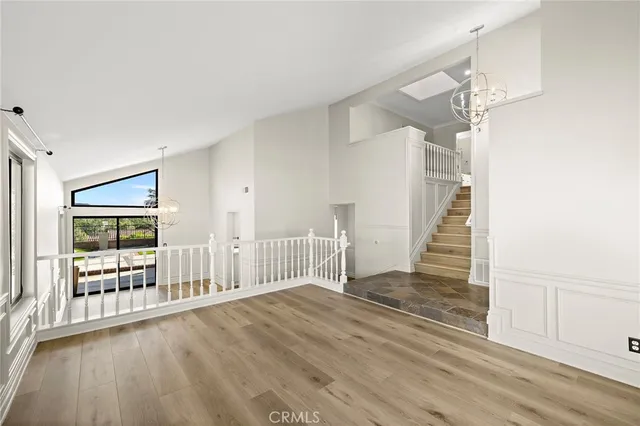 a view of a livingroom with wooden floor and stairs