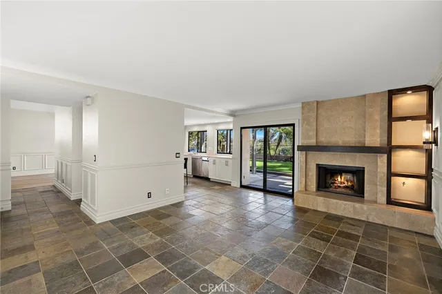 an empty room with windows and fireplace