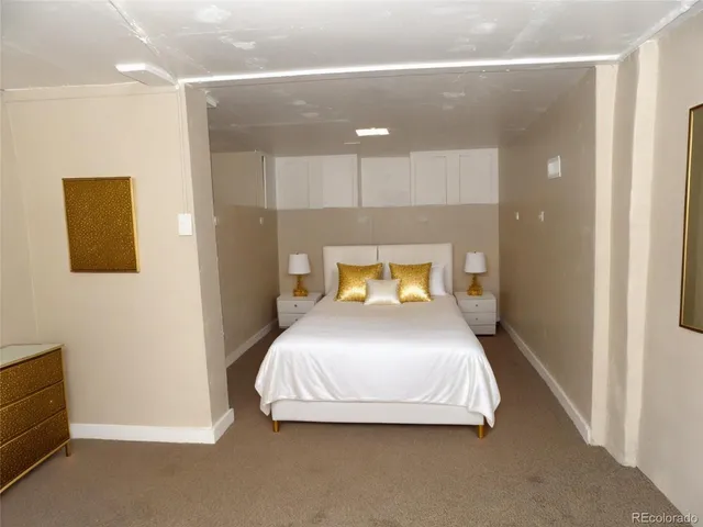 a bedroom with a bed and a painting on the wall