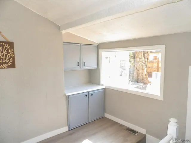 a view of a kitchen with wooden floor and a window