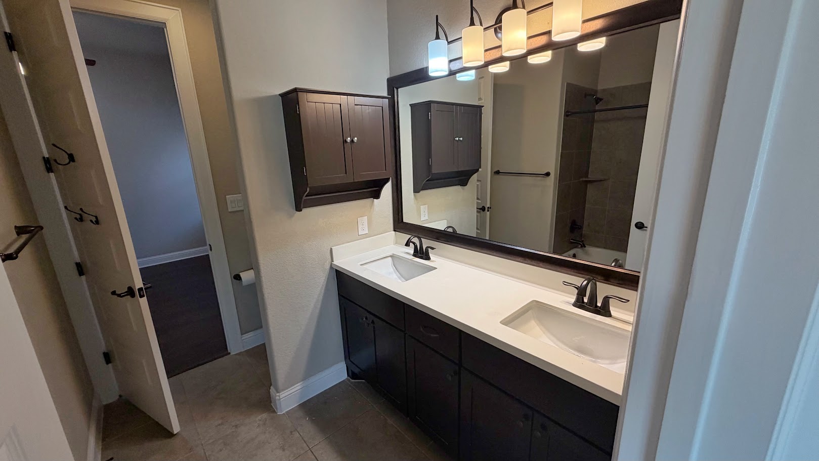 A well-appointed bathroom features a spacious dual vanity and elegant tile flooring.