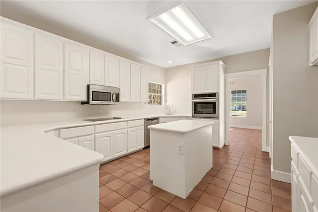 a kitchen with a sink a stove top oven and cabinets