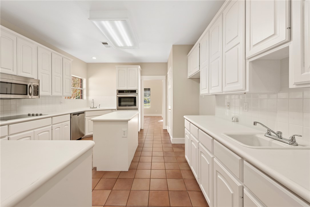417 Morgan Street Franklin, TX 77856 - Photo 16 of 42 a kitchen with a sink dishwasher stove and white cabinets with wooden floor