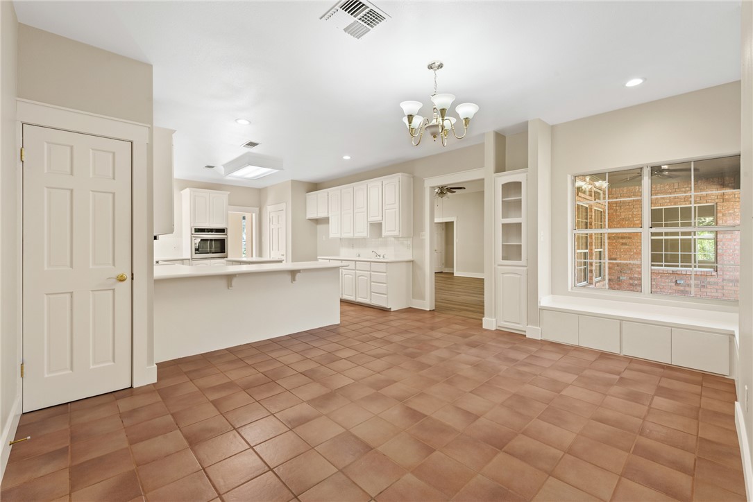 417 Morgan Street Franklin, TX 77856 - Photo 20 of 42 a large white kitchen with kitchen island a chandelier stainless steel appliances cabinets and a counter top space