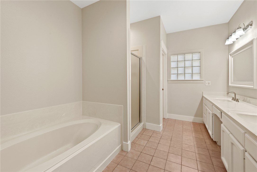 417 Morgan Street Franklin, TX 77856 - Photo 29 of 42 a bathroom with a bathtub a sink a vanity and a shower