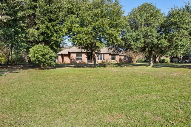 a front view of a house with a big yard