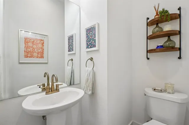 a bathroom with a sink mirror and toilet