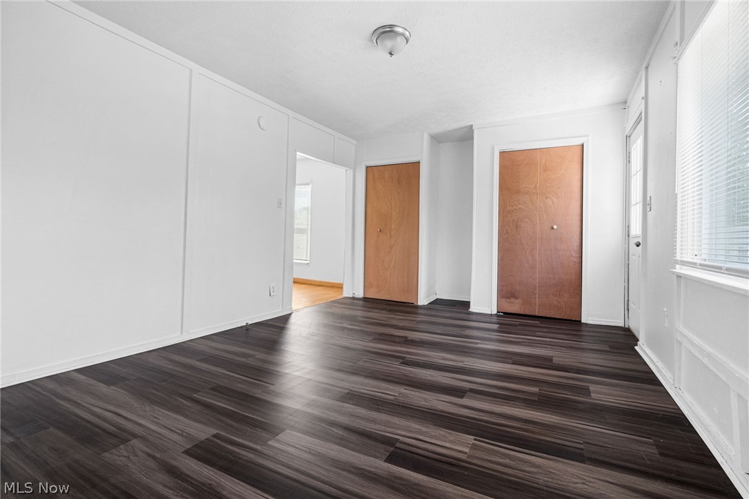 2387 29th Street Southwest Akron, OH 44314 - Photo 17 of 24 Unfurnished bedroom featuring dark wood finished floors and a decorative wall