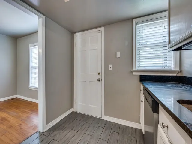 a view of a kitchen with wooden floor and windows