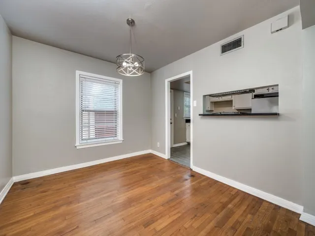 a view of a kitchen with wooden floor and a ceiling fan