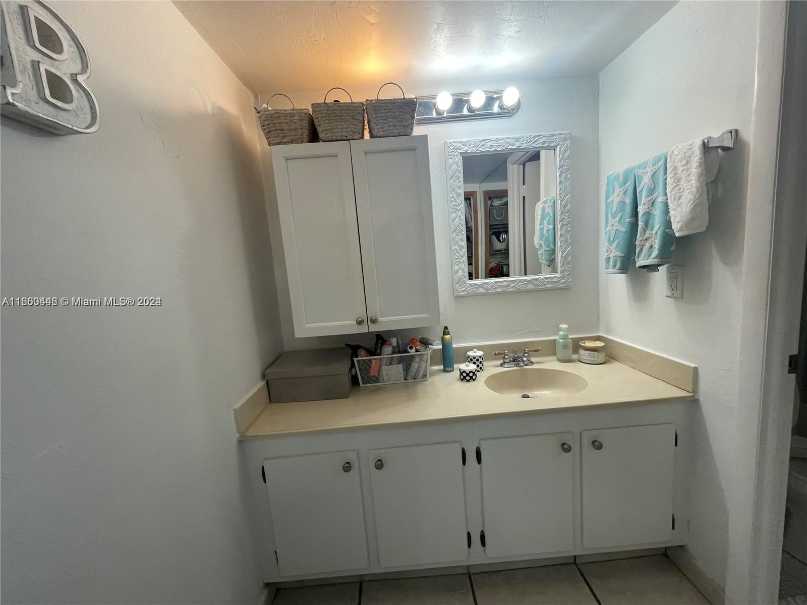 9273 Collins Avenue, Unit 811 Surfside, FL 33154 - Photo 17 of 25 a bathroom with a double vanity sink and mirror