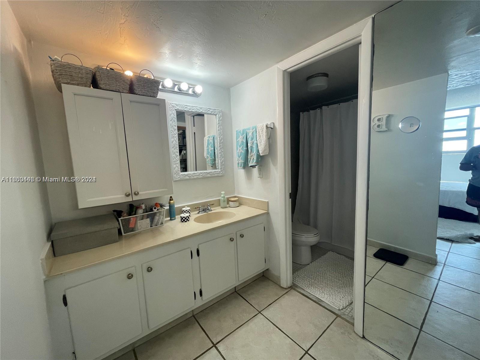 9273 Collins Avenue, Unit 811 Surfside, FL 33154 - Photo 18 of 25 a bathroom with a double vanity sink mirror and toilet