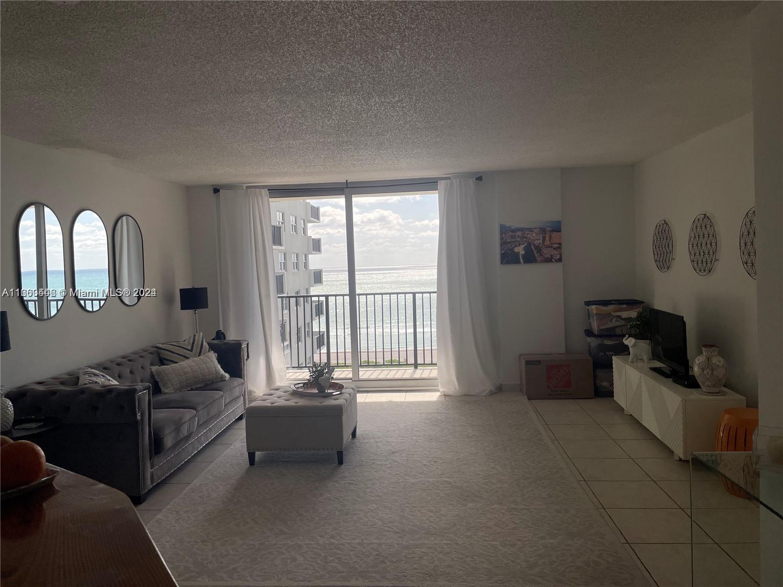9273 Collins Avenue, Unit 811 Surfside, FL 33154 - Photo 4 of 25 a living room with furniture and a large window