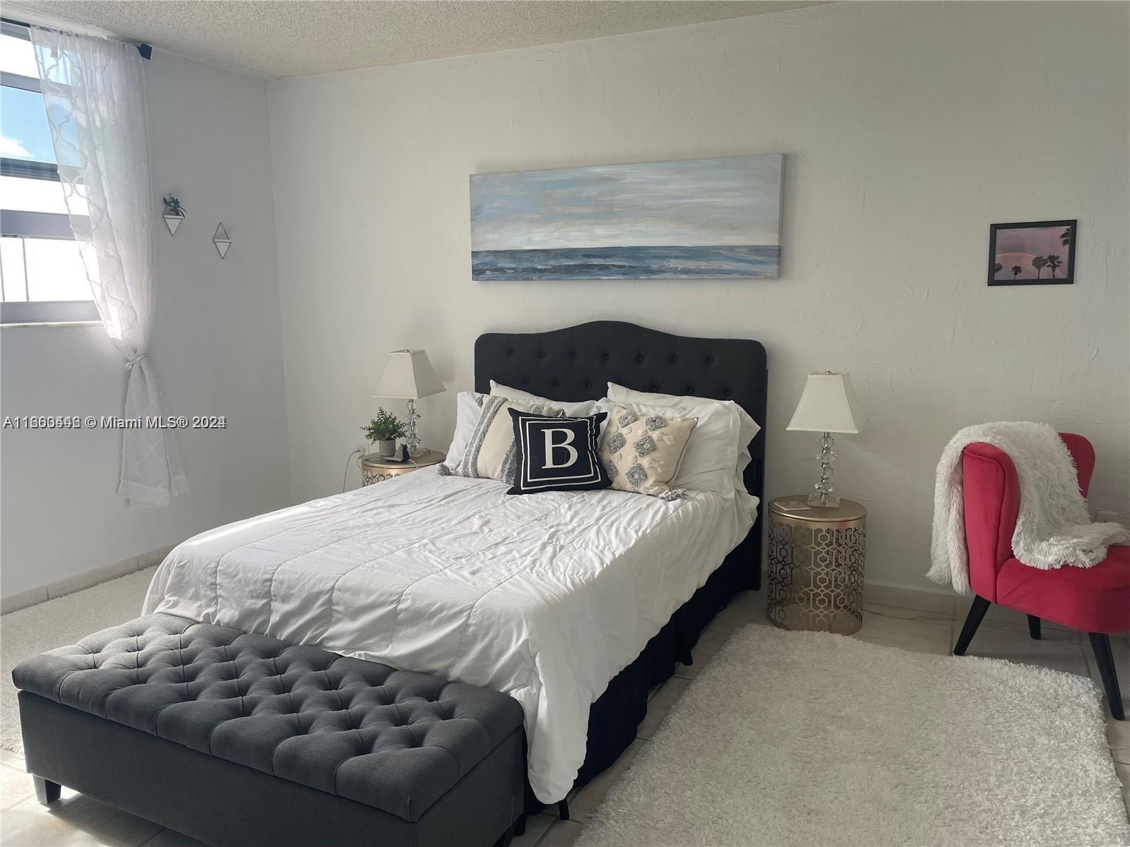 9273 Collins Avenue, Unit 811 Surfside, FL 33154 - Photo 8 of 25 a bedroom with a bed chair and table