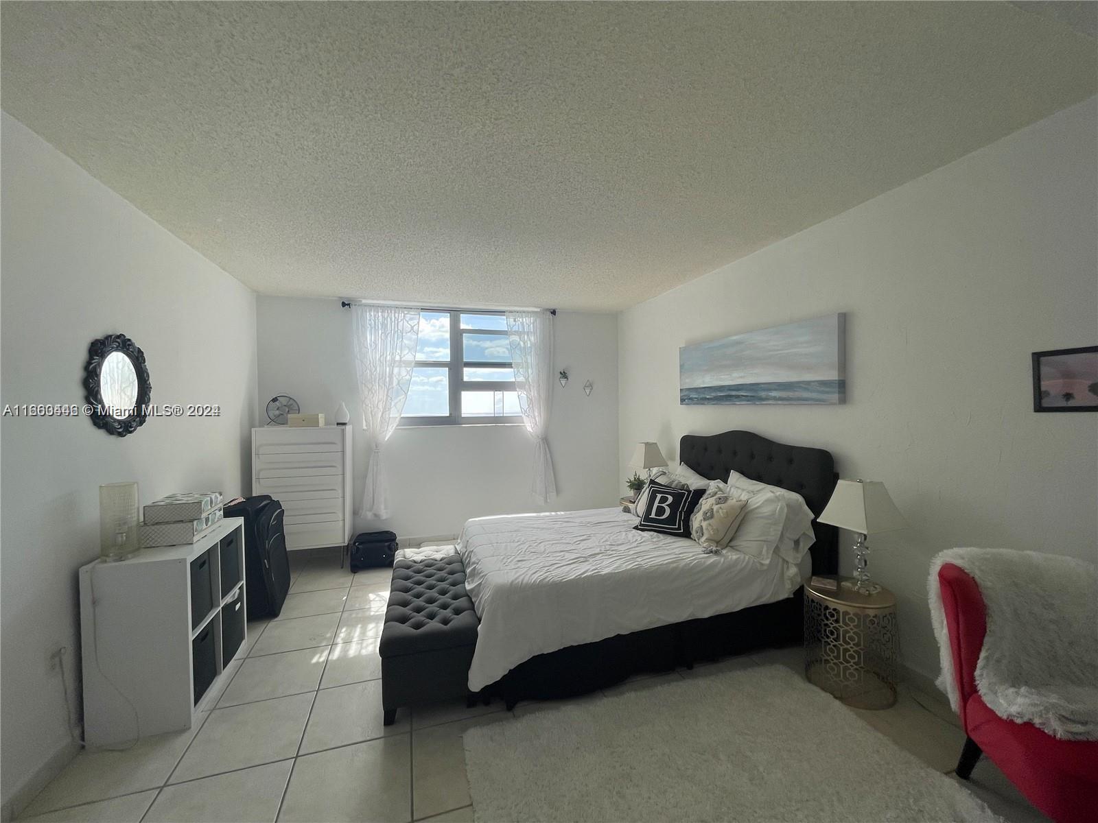 9273 Collins Avenue, Unit 811 Surfside, FL 33154 - Photo 9 of 25 a bedroom with a bed and a window