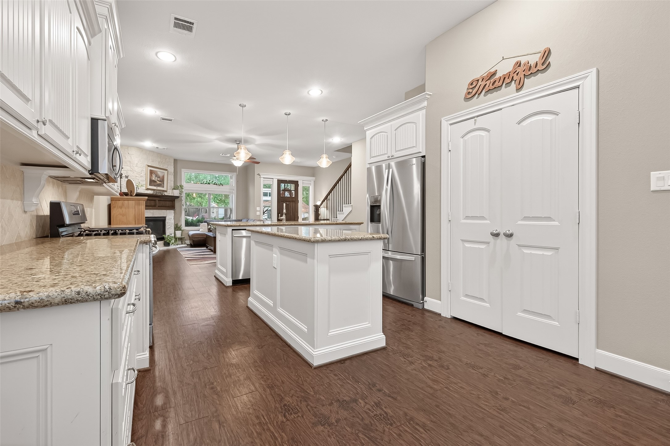 112 Timberside Drive Conroe, TX 77304 - Photo 12 of 50 a kitchen with stainless steel appliances granite countertop a refrigerator a oven a sink and white cabinets with wooden floor