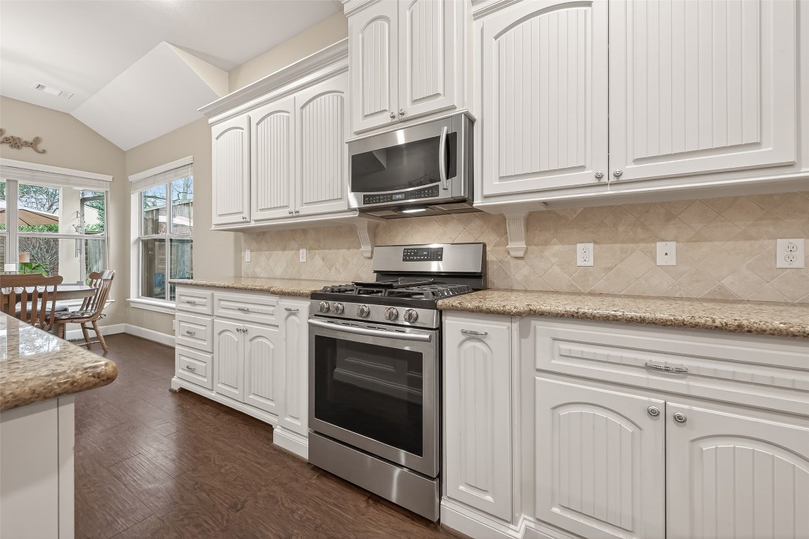 112 Timberside Drive Conroe, TX 77304 - Photo 15 of 50 a kitchen with granite countertop white cabinets and stainless steel appliances