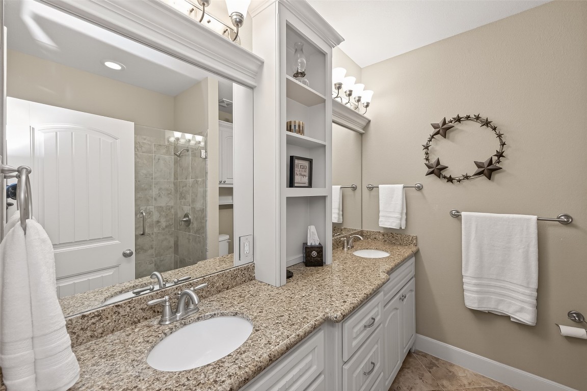 112 Timberside Drive Conroe, TX 77304 - Photo 34 of 50 a bathroom with a granite countertop double vanity sink a mirror and shower