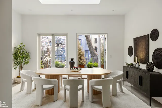 a dining room with furniture large windows and wooden floor