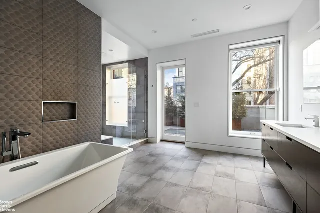 a spacious bedroom with a bed and glass window