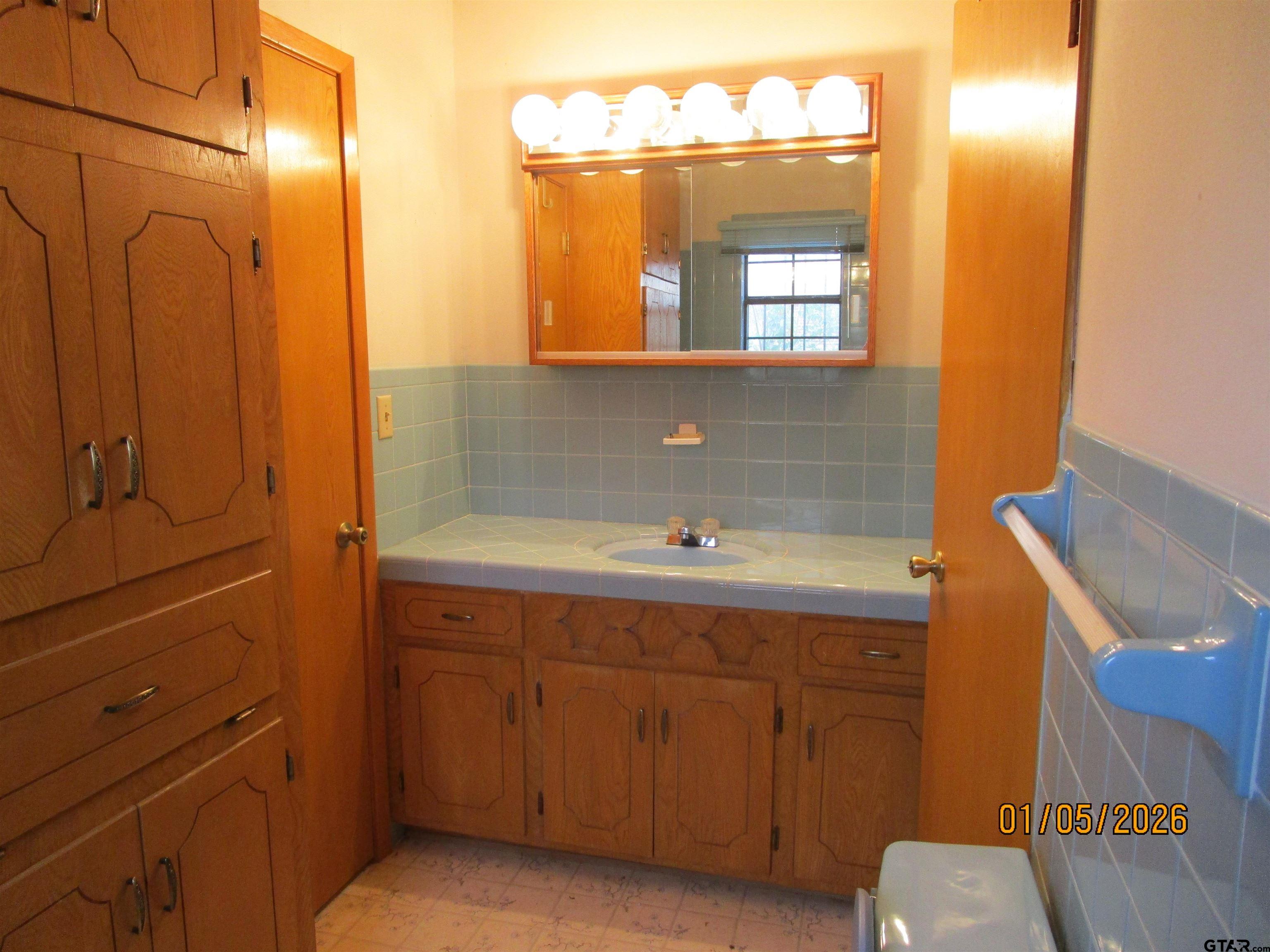 1317 South Butler Avenue Tyler, TX 75701 - Photo 9 of 13 a bathroom with a sink and a mirror