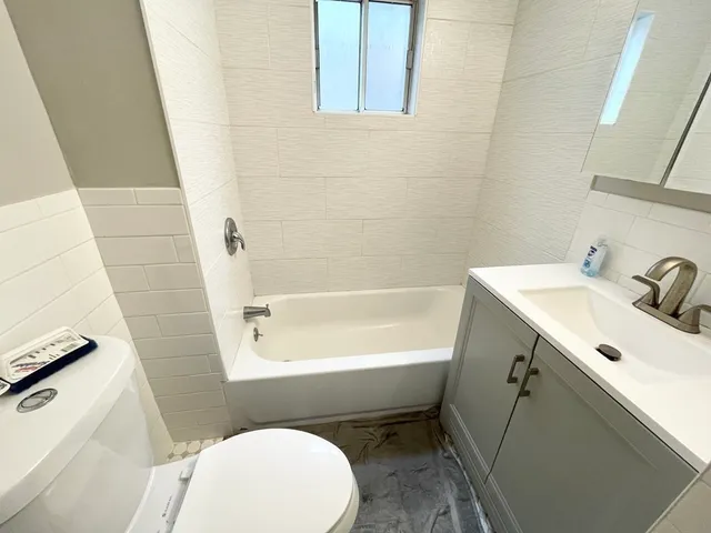 a bathroom with a sink a toilet a mirror and shower