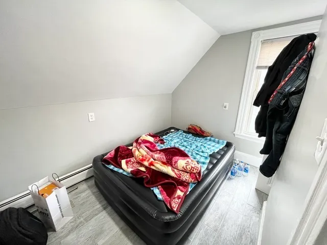 a bed sitting in a bedroom next to a window