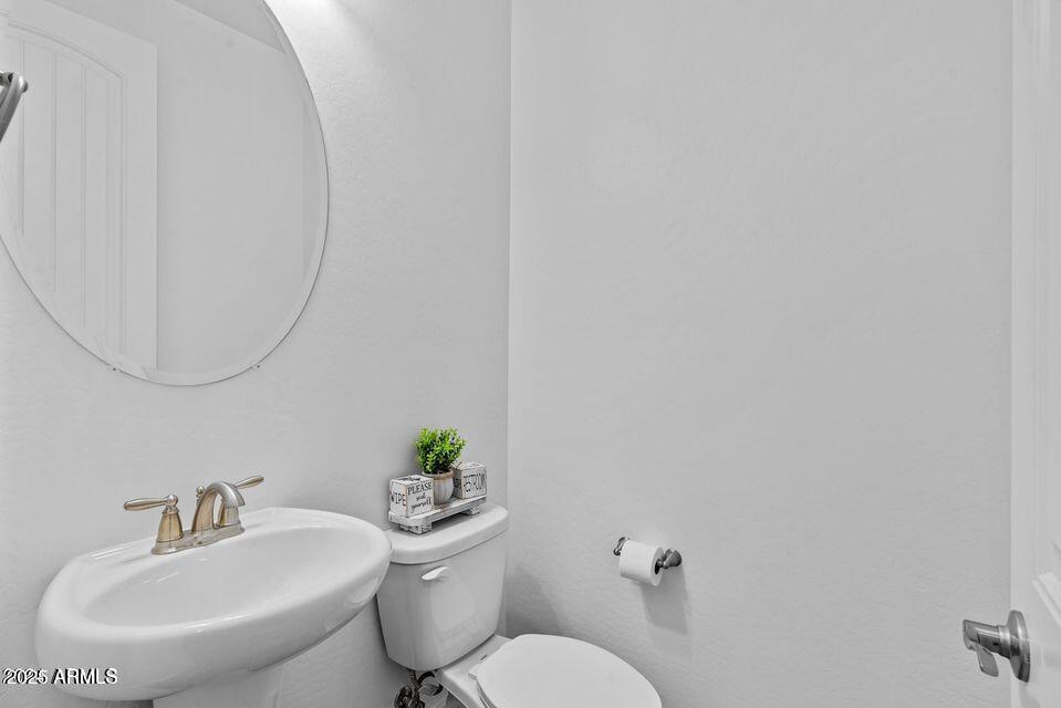 40990 West Agave Road Maricopa, AZ 85138 - Photo 12 of 18 a bathroom with a sink mirror and toilet
