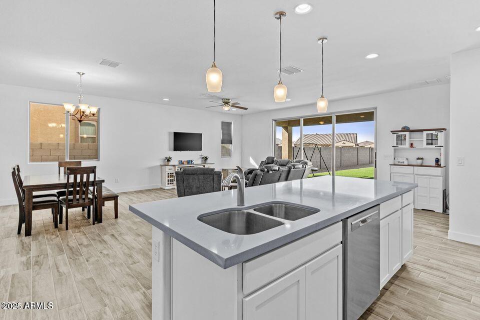40990 West Agave Road Maricopa, AZ 85138 - Photo 5 of 18 a kitchen with stainless steel appliances granite countertop a sink a stove and a wooden floors