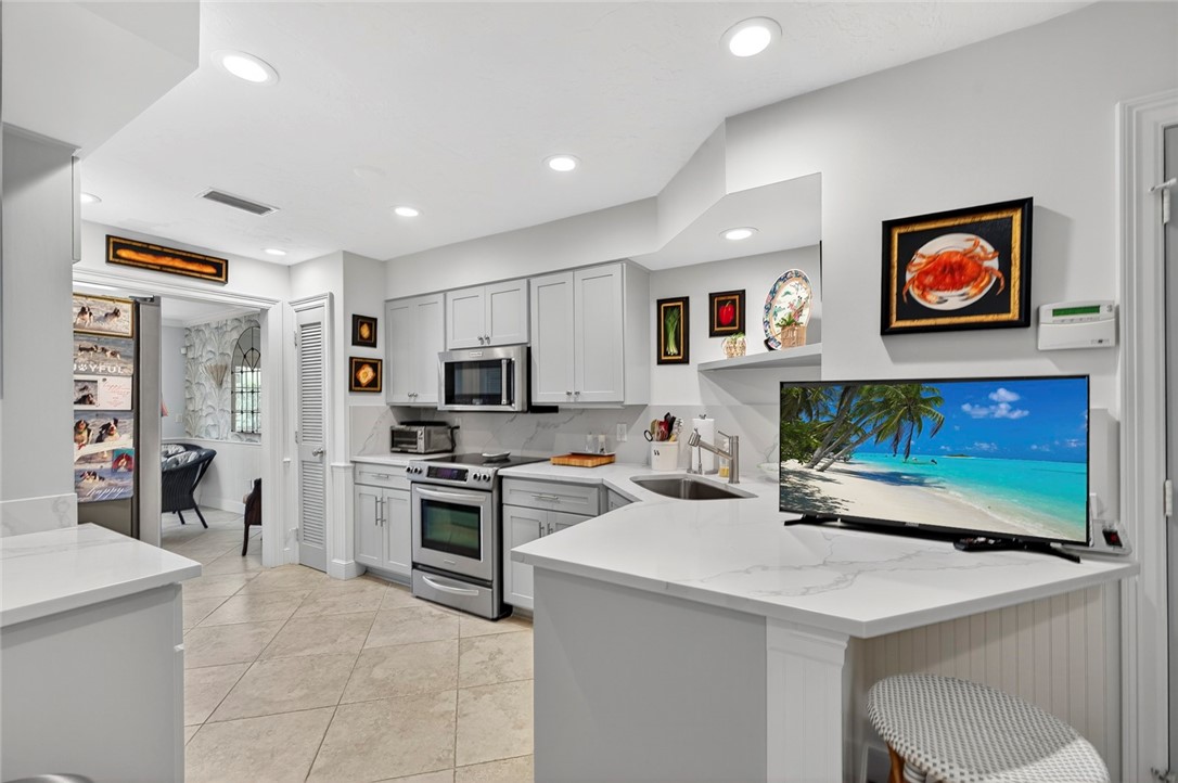 2525 Ocean Drive, Unit 3 Vero Beach, FL 32963 - Photo 8 of 36 a kitchen with stainless steel appliances a stove refrigerator sink and a microwave